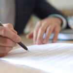 Picture of a person signing a contract